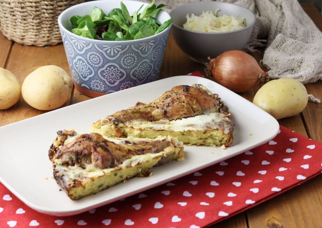 Kljukuša served on the table with two salads, potato and an onion in the background