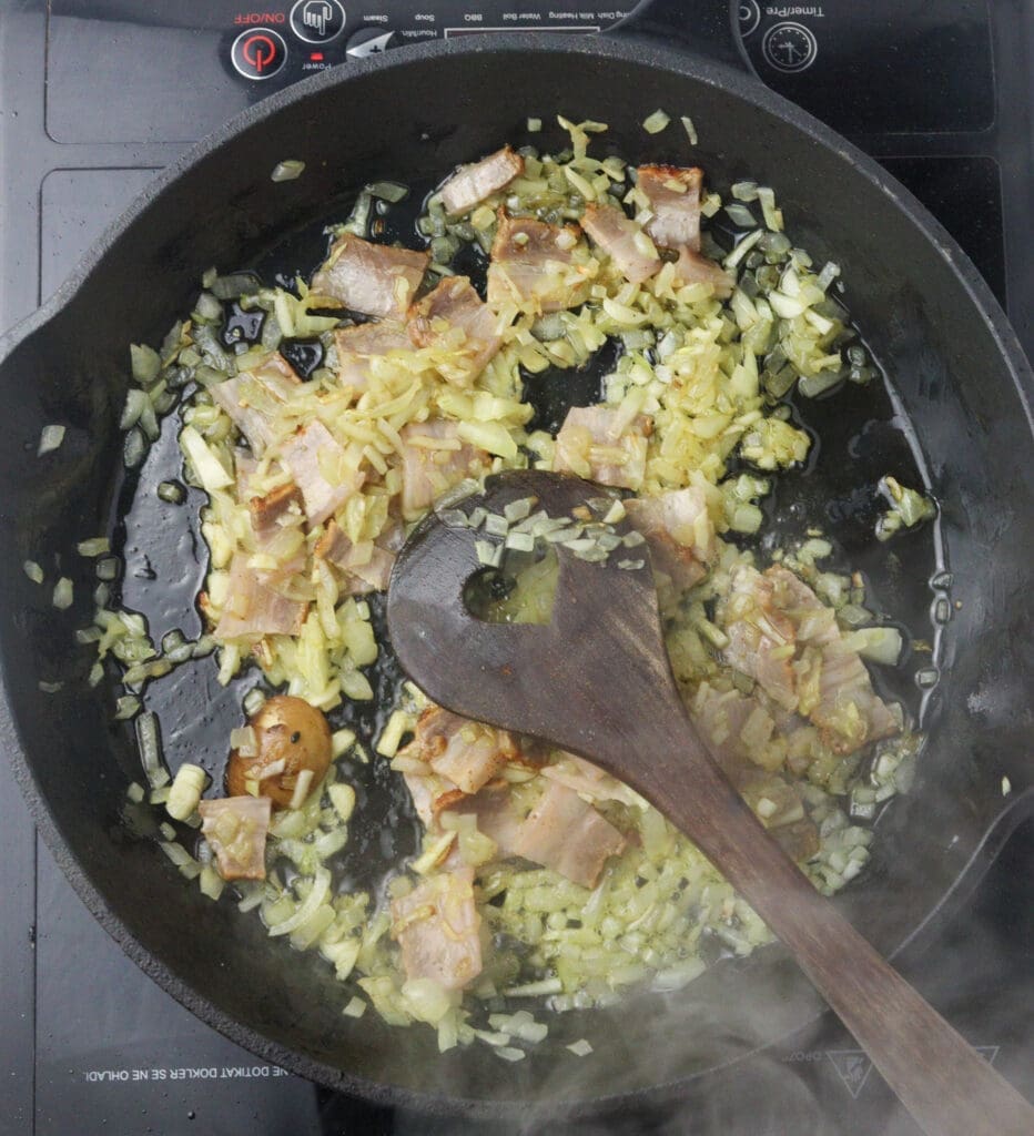 adding bacon to the sauteed onions 