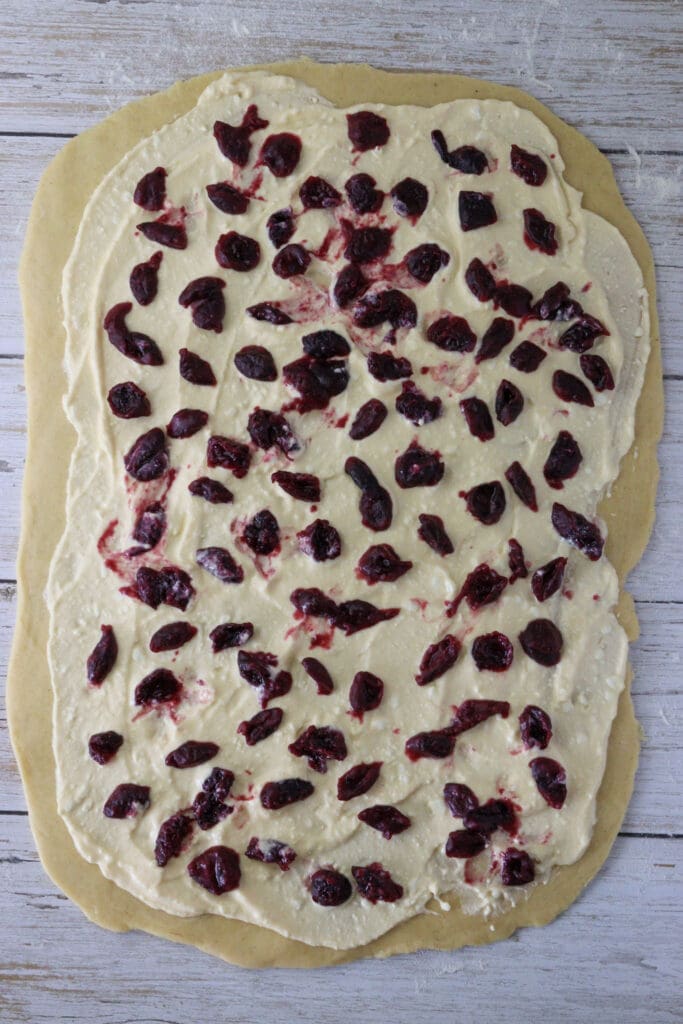 image of the babka dough topped with cottage cheese and cherries