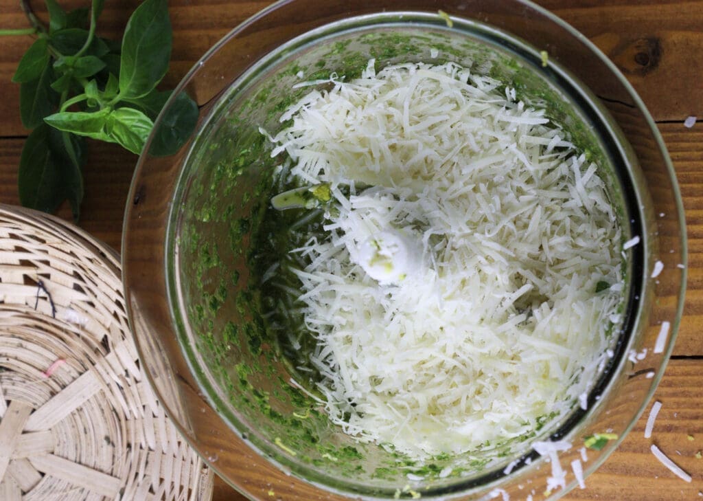 image of how to add grated grana padano to the pesto mixture