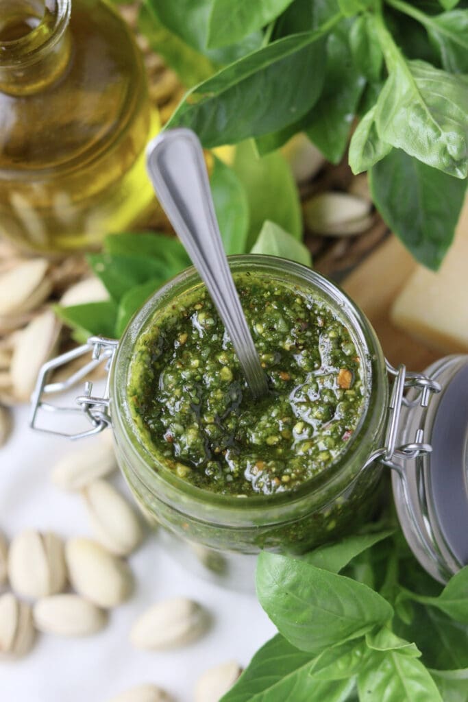 image of how pesto looks like with blended olive oil, basil leaves grana padano cheese and pistachios