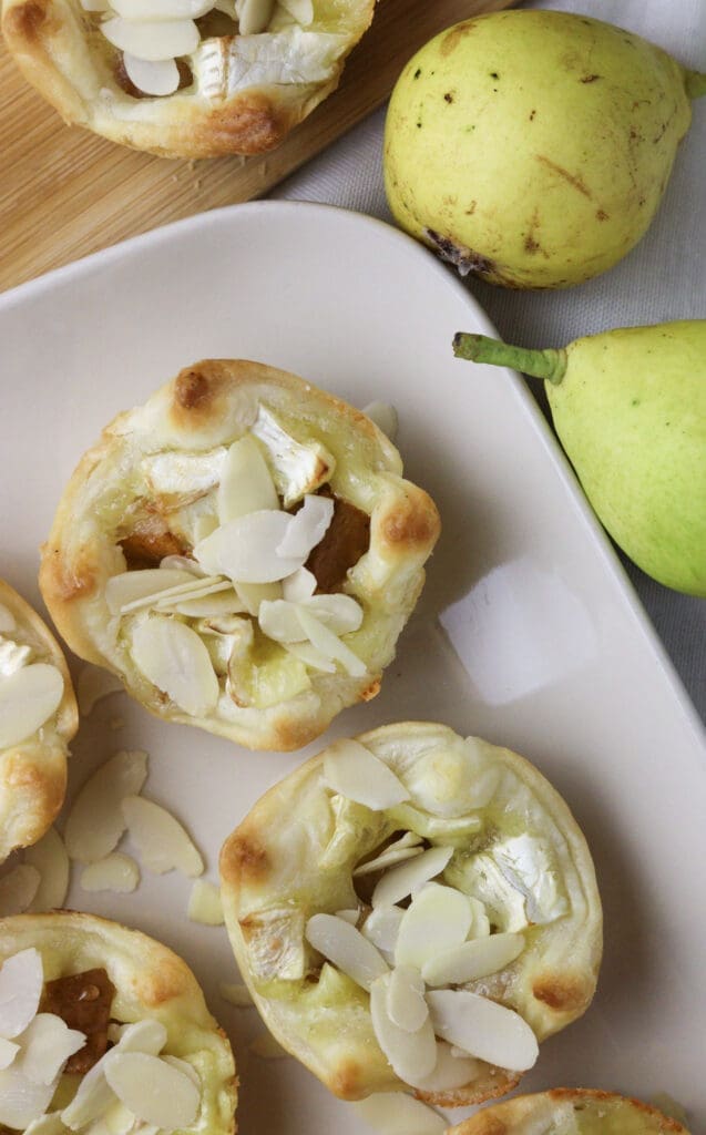 brie and pear puff pastry bites served on a white plate 