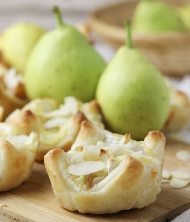 brie and pear puff pastry bites served with honey and sliced almonds