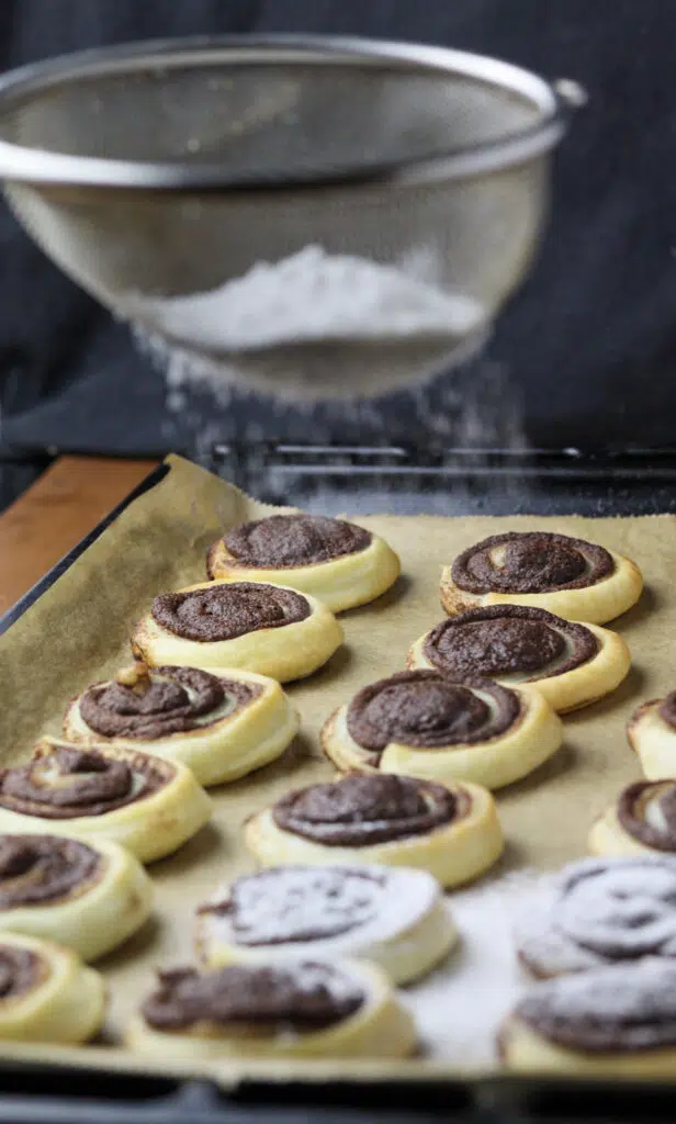 image showing how to sprinkle the pinwheels with powdered sugar