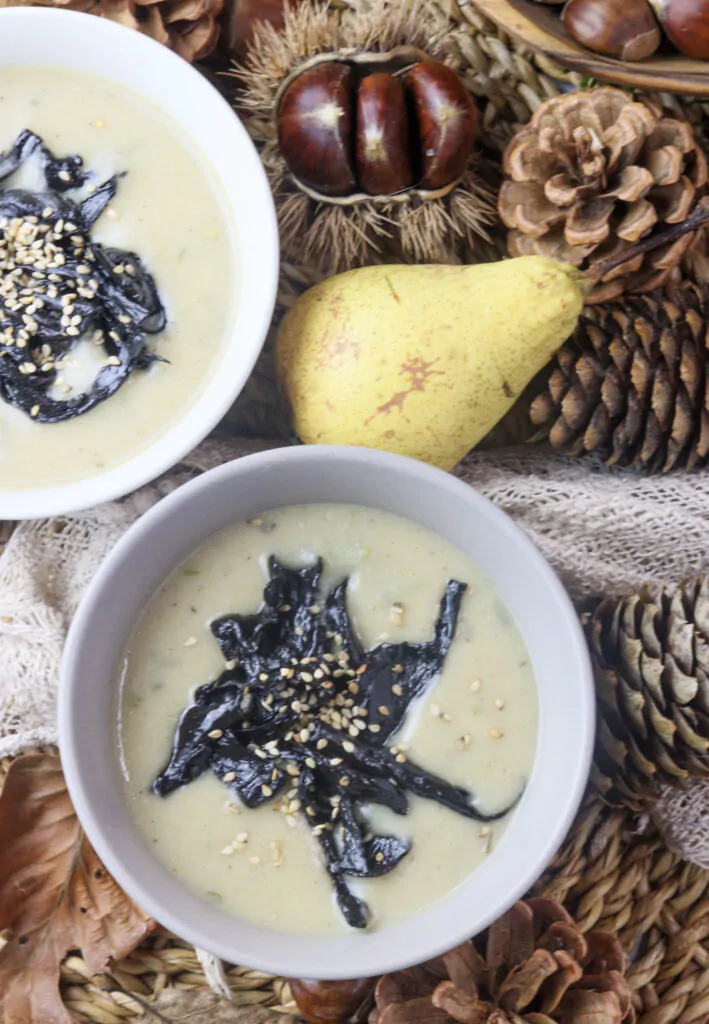 pear potato soup with mushrooms on the table with pears and chestnuts in the background