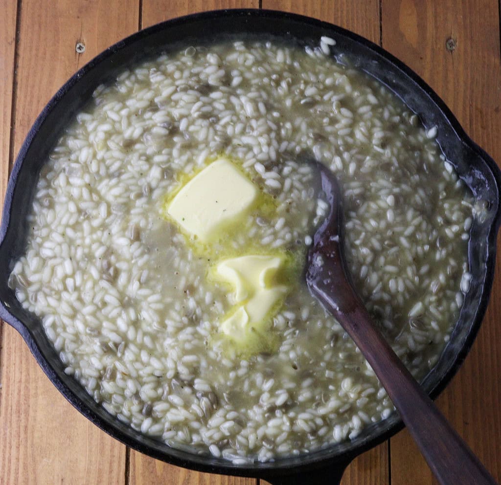 image showing how to add butter to risotto and stir it with rice