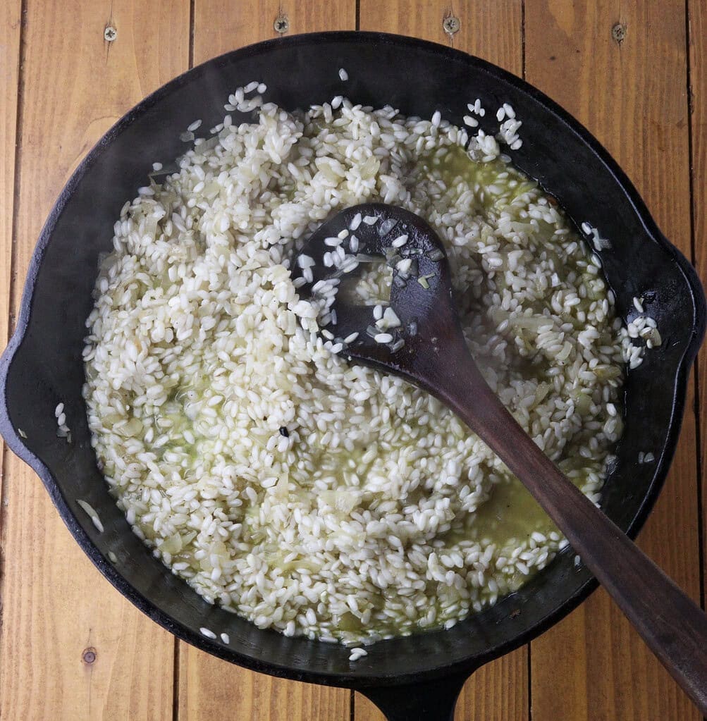 image showing how to add rice to the pan and pour in wine