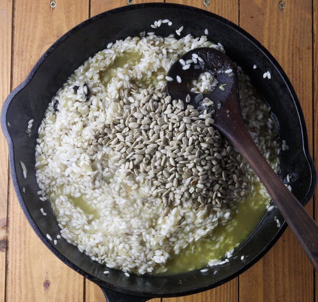 image showing how to add toasted sunflower seeds to risotto pan