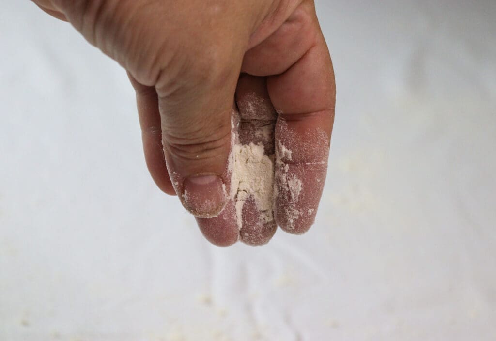 how to sprinkle the covered kitchen table with flour before stretching the strudel dough