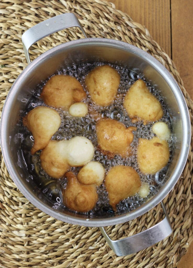 Frying dough balls in oil.