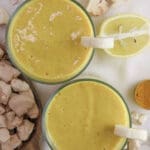 two glasses of healthy baobab smoothie with ginger and baobab fruit in the background