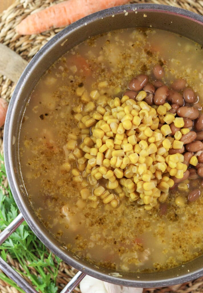Adding beans and corn at the end of cooking the minestra soup.
