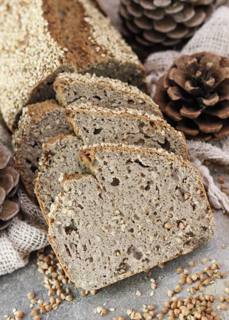 A loaf of gluten-free buckwheat soda bread cut into three thick rustic slices.