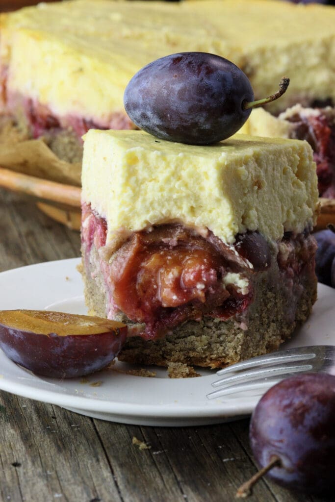 A juicy middle of a slice of plum cheesecake with a goey plum layer and fresh plums 