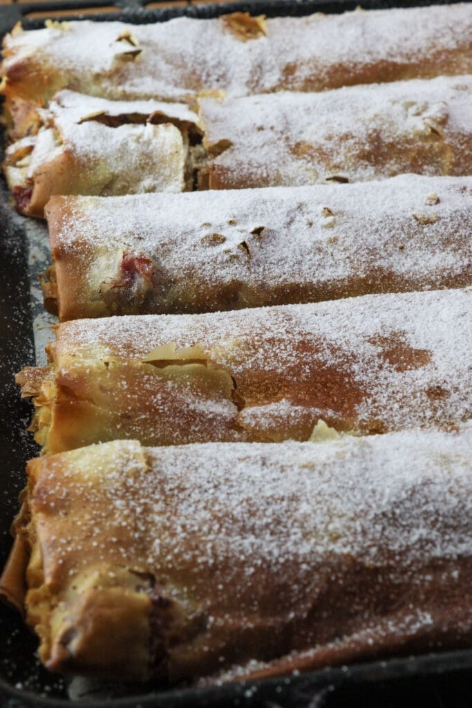 A full baking pan of delicious plum strudel powdered with sugar, the best and the easiest plum dessert.