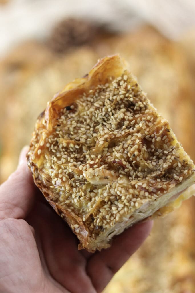 A piece of chicken of the woods pie topped with sesame seeds.
