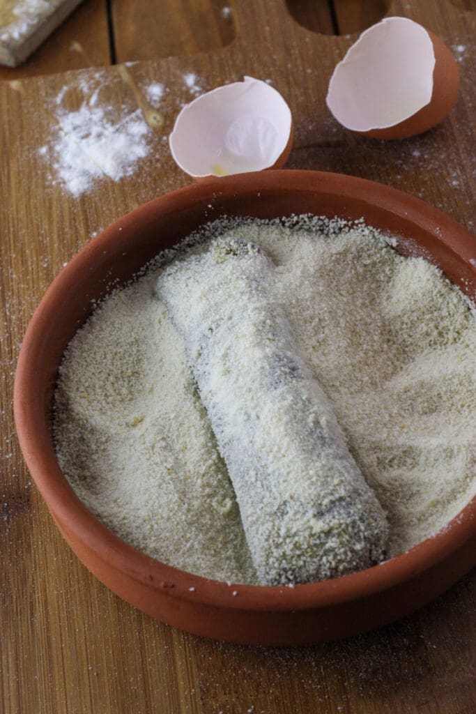 Coating the rolls in breadcrumbs before frying.