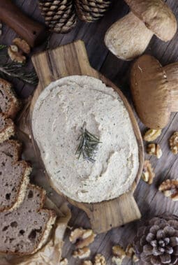 Delicious, creamy porcini mushroom walnut pate with walnuts, porcini mushrooms, rosemary and fresh bread in the background