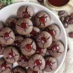 A plate of buckwheat cookies with strawberry jam with rose hip buds, spruce branch and cup of jam.