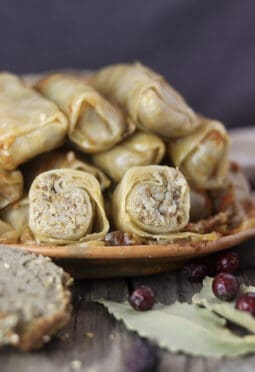 A plate of stuffed sour cabbage rolls with buckwheat and homemade buckwheat bread beside the plate.