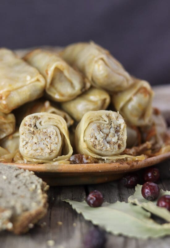 A plate of stuffed sour cabbage rolls with buckwheat and homemade buckwheat bread beside the plate.