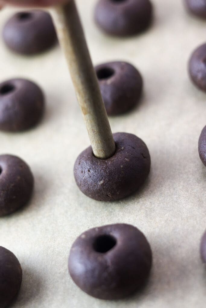 How to make holes in the cookie dough using a wooden spoon.