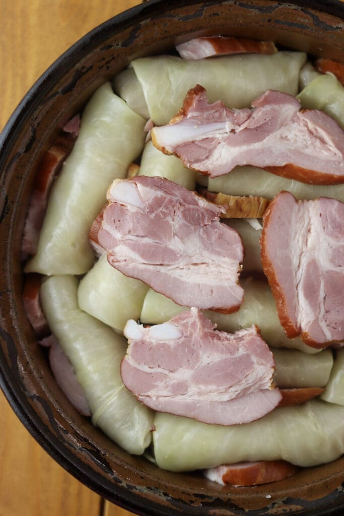 Adding slices of smoked pork ribs in between the layers of stuffed cabbage rolls with buckwheat.