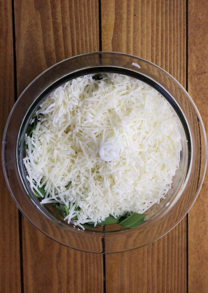 Parmesan added to a blender, with chopped wild garlic leaves, olive oil and a pinch of salt.