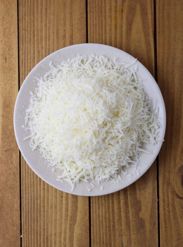 How to shred the parmesan cheese before adding it to a blender.