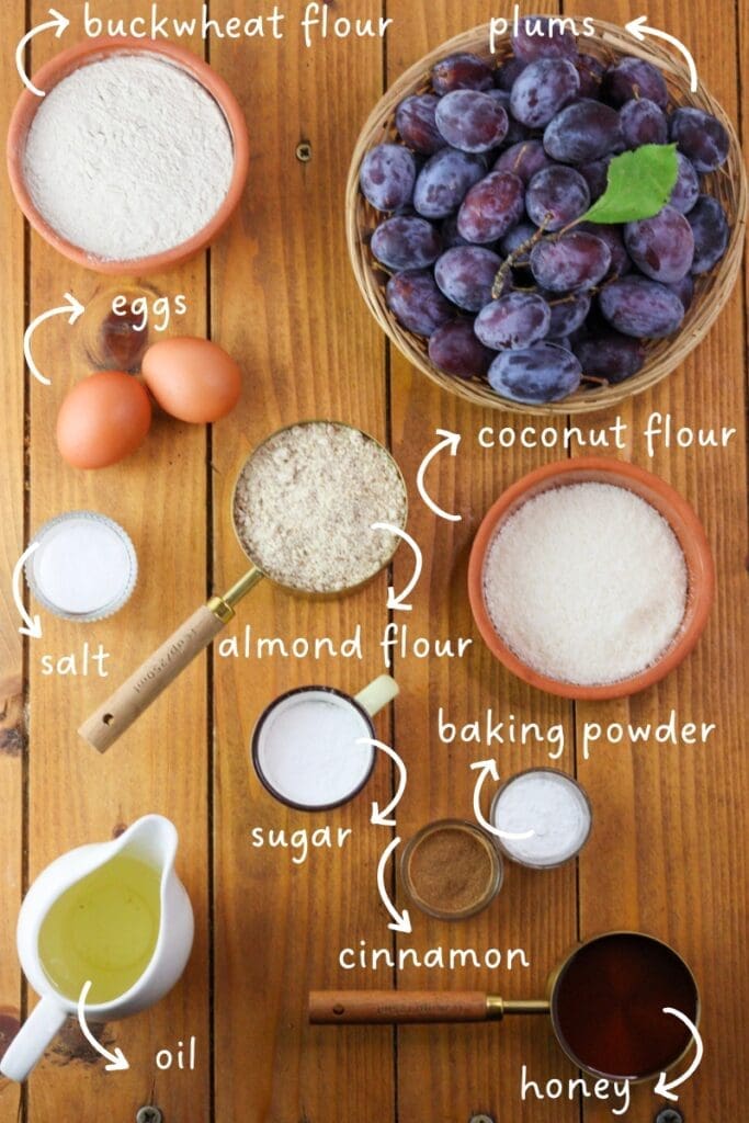 Ingredients mis en place for buckwheat upside down plum cake: buckwheat flour, fresh plums, coconut flour, almond flour, eggs, salt, baking powder, sugar, cinnamon, oil and honey.
