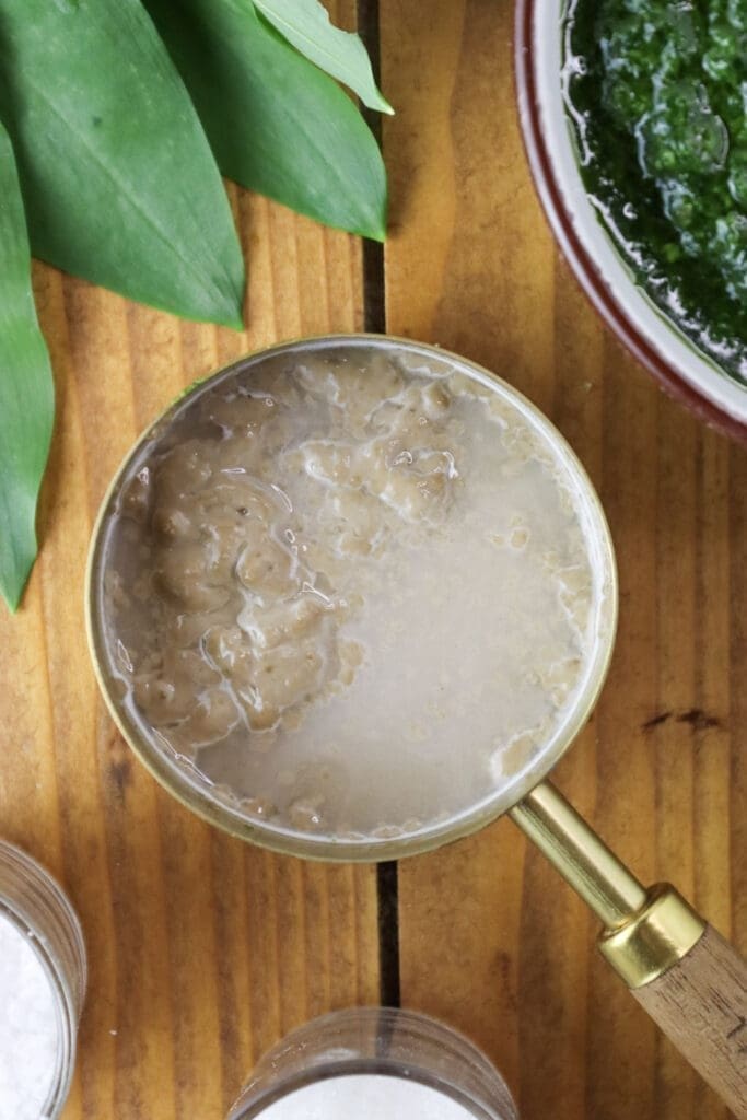 Soaking dried yeast in warm water with sugar to activate it before kneading the dough